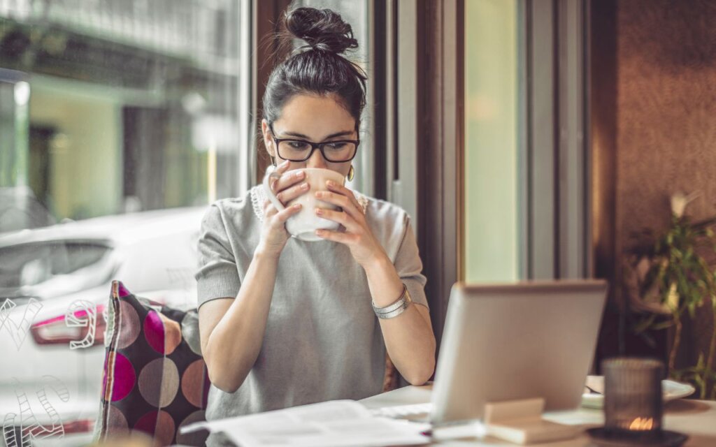 コーヒーを飲みながら仕事をする女性