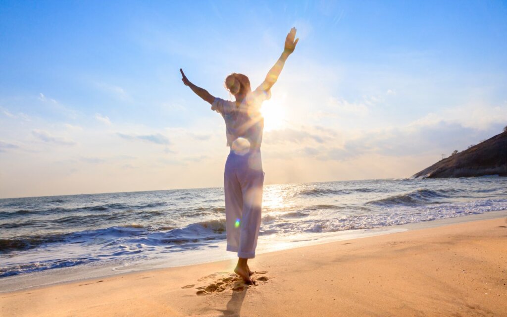 海辺で解放感に喜ぶ女性